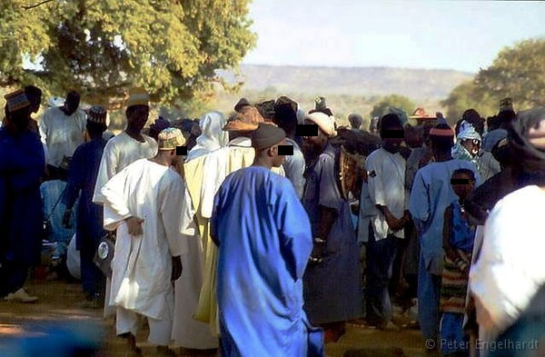 Afrikanische Männer gruppieren sich zu Gesprächsrunden auf einem Markt in Burkina Faso